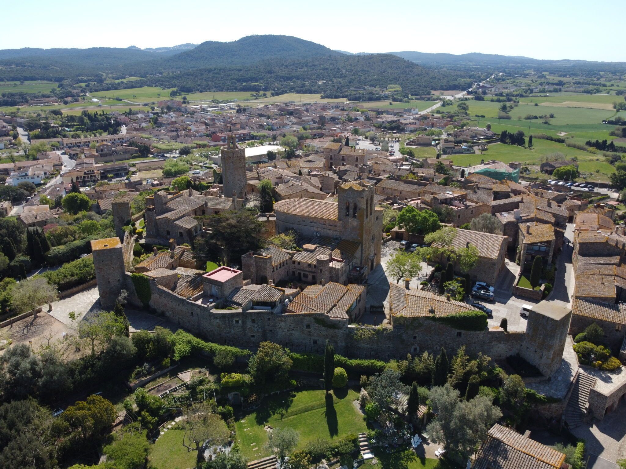 Vue aérienne d’une ville historique dotée d’une architecture médiévale, avec notamment un château imposant, flanqué de tours et entouré d’un rempart.