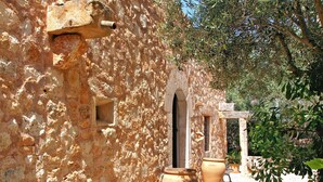 Un bâtiment en pierre, doté d’arcades et de grands pots en terre cuite.