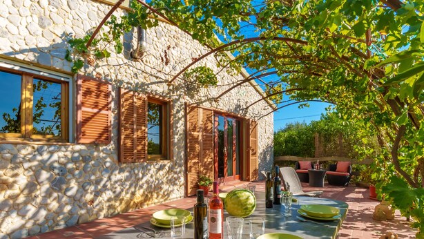 Un edificio de piedra con un espacio exterior habilitado para comedor.