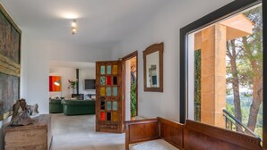 Ein geräumiges Wohnzimmer mit großem Fenster, einer hölzernen Bank, einem grünen Sofa und einem Kamin.