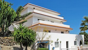A multi-story building with a white facade and terracotta roof tiles. - Cuevecitas by Interhome (Candelaria)