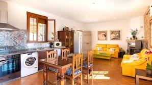 Un espacio habitable pequeño con cocina, comedor y sofá.