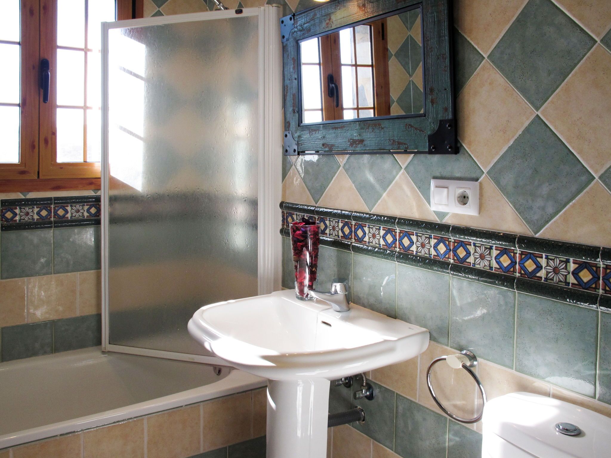 A bathroom with a shower, sink, and toilet.