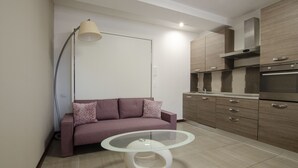 Una cocina moderna con sofá y una mesa de centro de vidrio.
