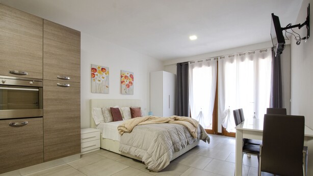 Un dormitorio moderno con cama, escritorio y televisor.