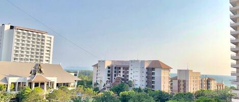 A hotel with multiple floors, a flat roof, and a view of the sea.
