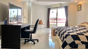 A hotel room with a bed, a desk with a chair, a television, and a balcony with a view. - 1 Bedroom Seaview 706 Kiengtalay (Pattaya)