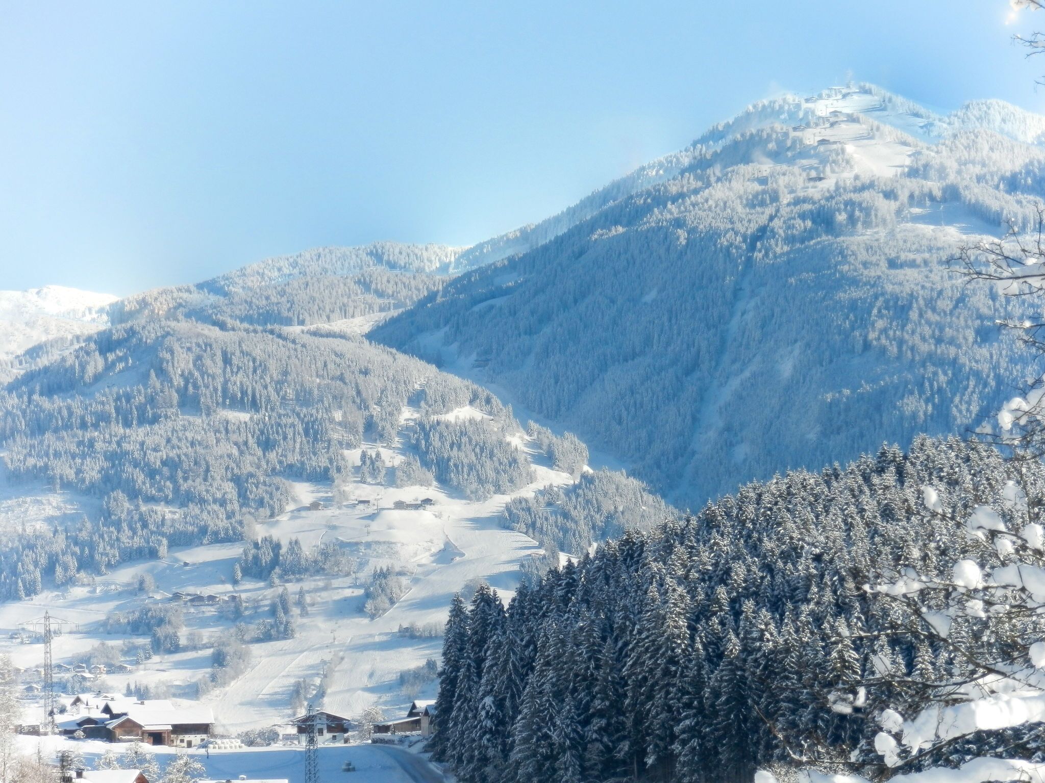 A mountainous landscape with snow-covered trees and buildings.