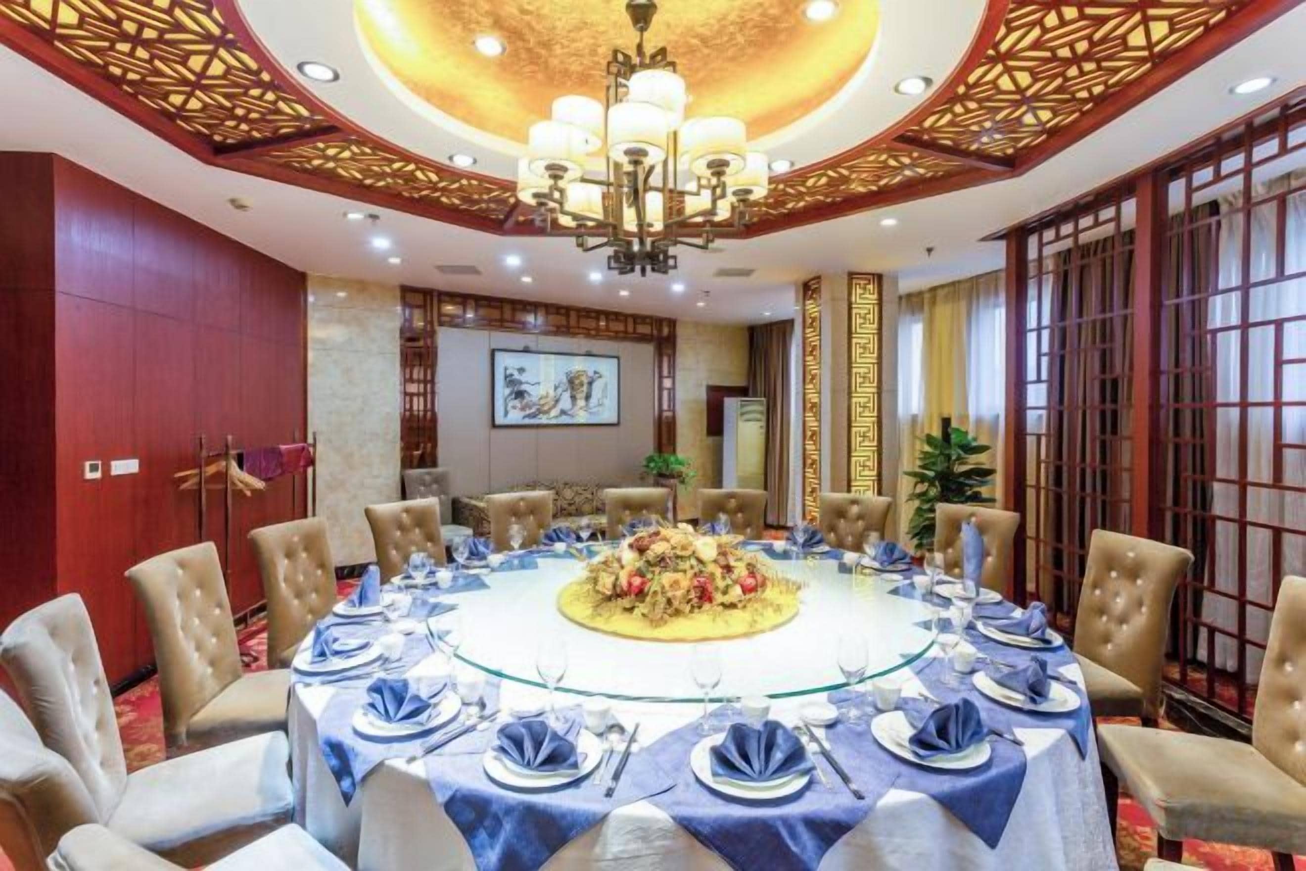 A conference room with a round table, chairs, and a chandelier.