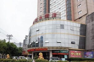 A multi-story building with a curved facade, signage indicating a hotel and a public education center, and a visible entrance with a canopy.
