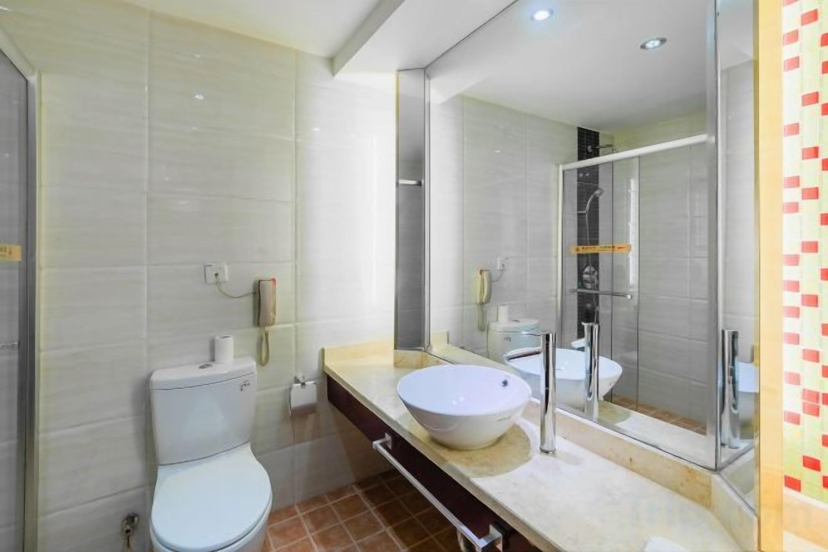A modern bathroom with a toilet, sink, and shower.