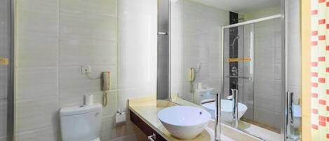 A modern bathroom with a toilet, sink, and shower.
