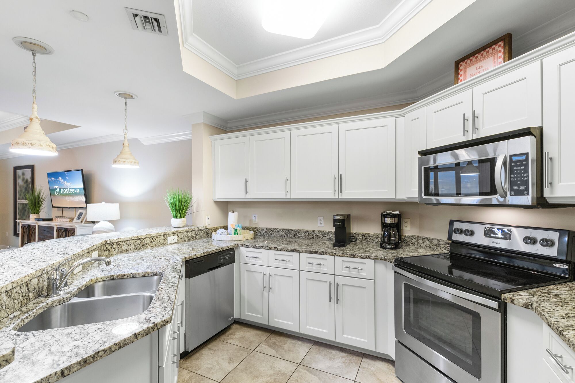 A modern kitchen with white cabinets, granite countertops, a built-in microwave, a stove, and a dishwasher.