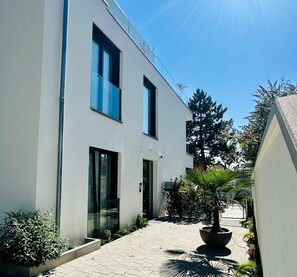 Stunning two-story building with large windows and a beautifully landscaped entrance.