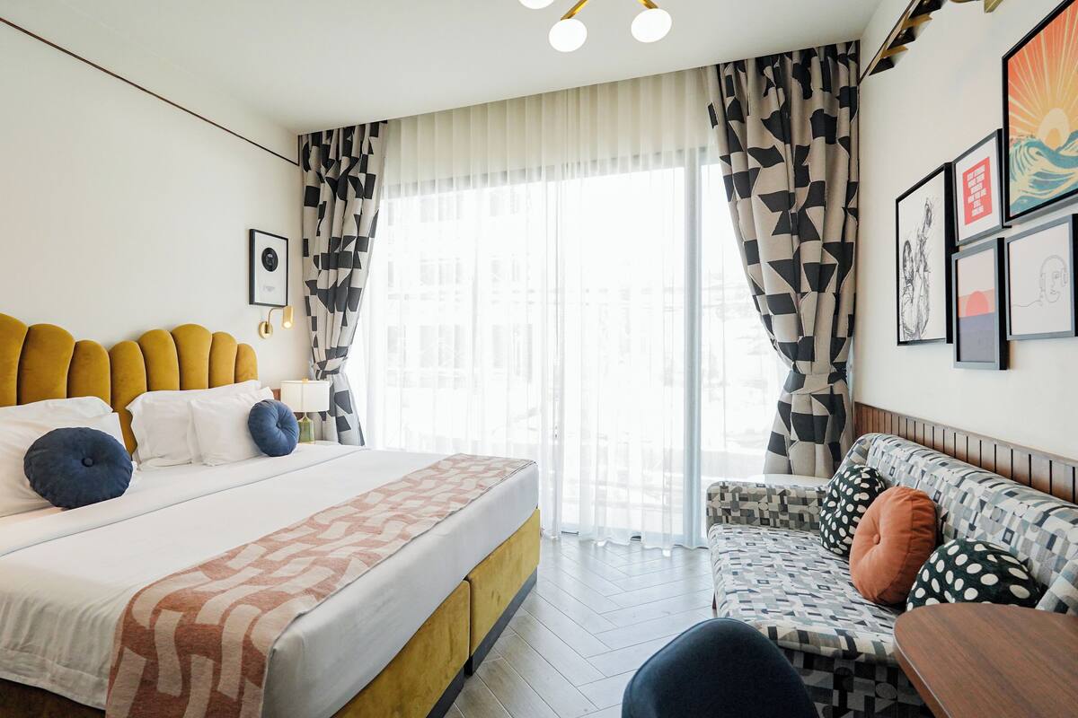Une chambre d’hôtel avec un lit, un canapé et une petite table.