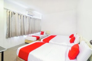 A hotel room with two beds, a small table, and a window with curtains. - OYO 44017 L & C Premium Stay  (Kuching)