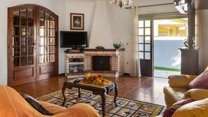 Una sala de estar con chimenea, televisor y un gran aparador de madera.