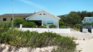 Ein modernes Haus mit Garage, umgeben von viel Grün und blauem Himmel.