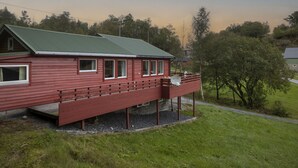 A red wooden house with a green roof, a balcony, and a satellite dish. - Fjordglytt by Interhome (Onarheim)