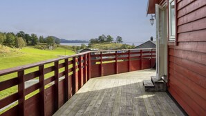 A wooden deck with a view of a lake and hills. - Fjordglytt by Interhome (Onarheim)