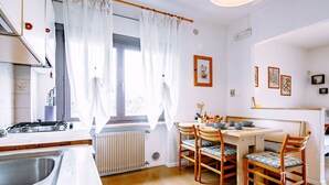 Eine moderne Küche mit Essbereich, ausgestattet mit Herd, Spüle und einem Esstisch mit Stühlen.