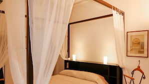 Une chambre à coucher comprenant un lit, une table de chevet, un porte-vêtements et un tableau encadré accroché au mur.