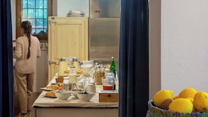 Une cuisine avec une arche en briques, une table à manger décorée de citrons et une personne à l’arrière-plan.
