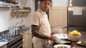Une cuisine avec un fourneau, des casseroles et un saladier rempli de citrons.