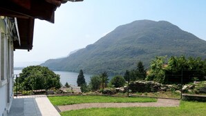 Une vue depuis un balcon donnant sur un lac, avec une montagne en arrière-plan.