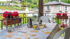 Une table dressée pour le dîner, avec vue sur des maisons et de la verdure.