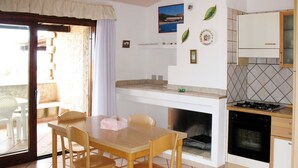 Une cuisine équipée d’une table et de chaises, d’une cuisinière, d’un four et d’un petit plan de travail.