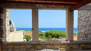 A stone-framed balcony with a view of the sea and greenery. - Residence Delphino (REI253) by Interhome (Costa Rei)