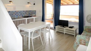 Ett kompakt bostadsutrymme med kök, matplats och balkong.