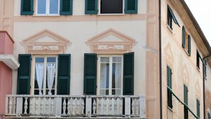 A building with a balcony and green shutters.