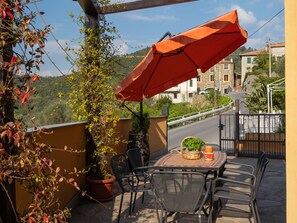 Enjoy a casual dining experience on this patio with a table for two, surrounded by a potted plant and a wicker basket.
