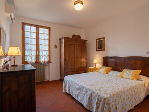 Ein Schlafzimmer mit einem Bett, einem Holzschrank und einem Vorhangfenster.