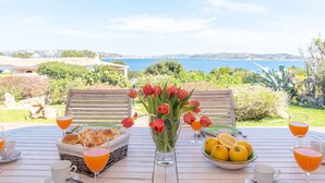 A table set with bread, lemons, and tulips, overlooking a coastal landscape. - Mare Blù by Interhome (Palau)