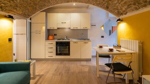 Una cocina moderna con armarios blancos, una estufa y un comedor con mesa y sillas.