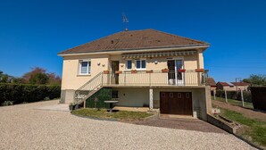 A two-story house with a balcony, a staircase, and a driveway. - Renovated Townhouse in Argy: Private Garden, Game Room, Near Château and ZooParc de Beauval (Argy)