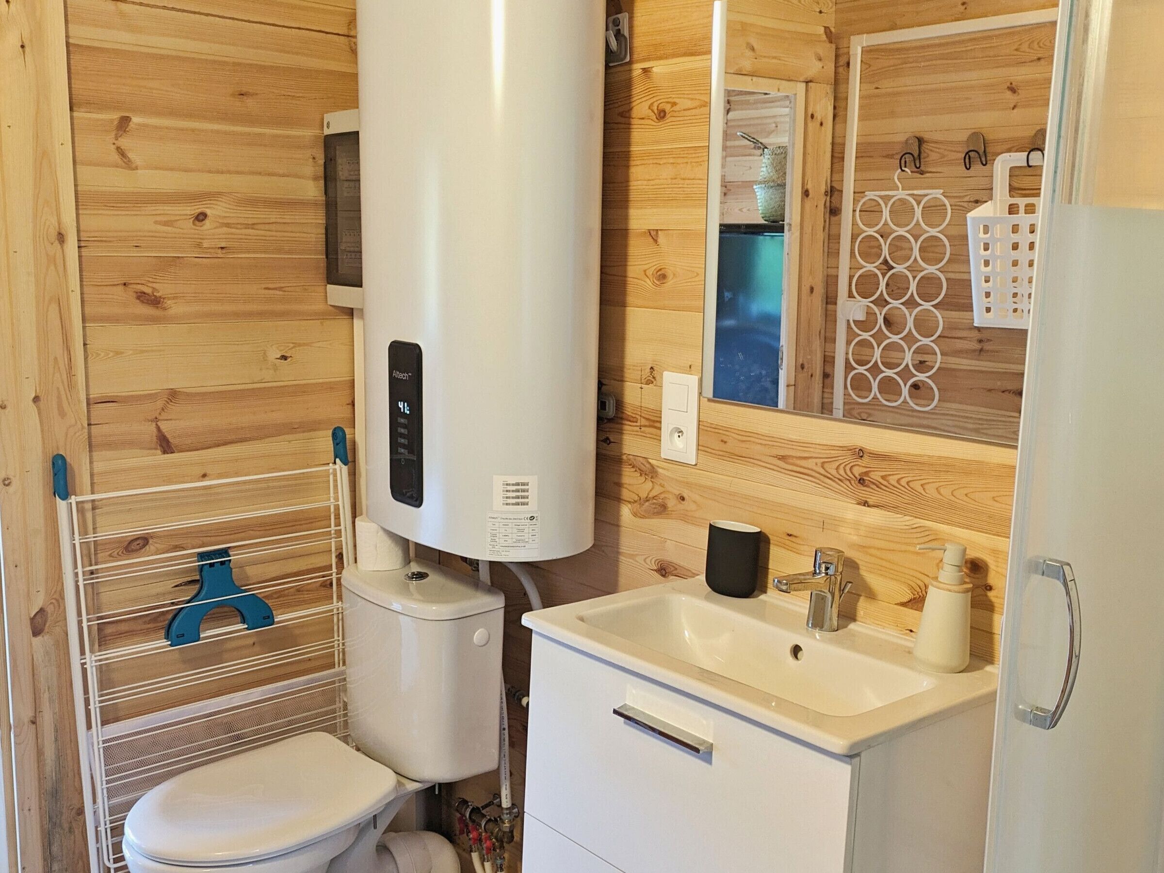 A compact bathroom with a toilet, sink, and a white heater.