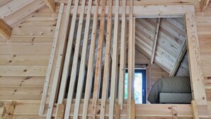 Un habitación estilo loft con vigas de madera a la vista, una ventana y vistas al exterior.