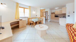 Un grand espace de vie comprenant une table à manger, une cuisine et un canapé.
