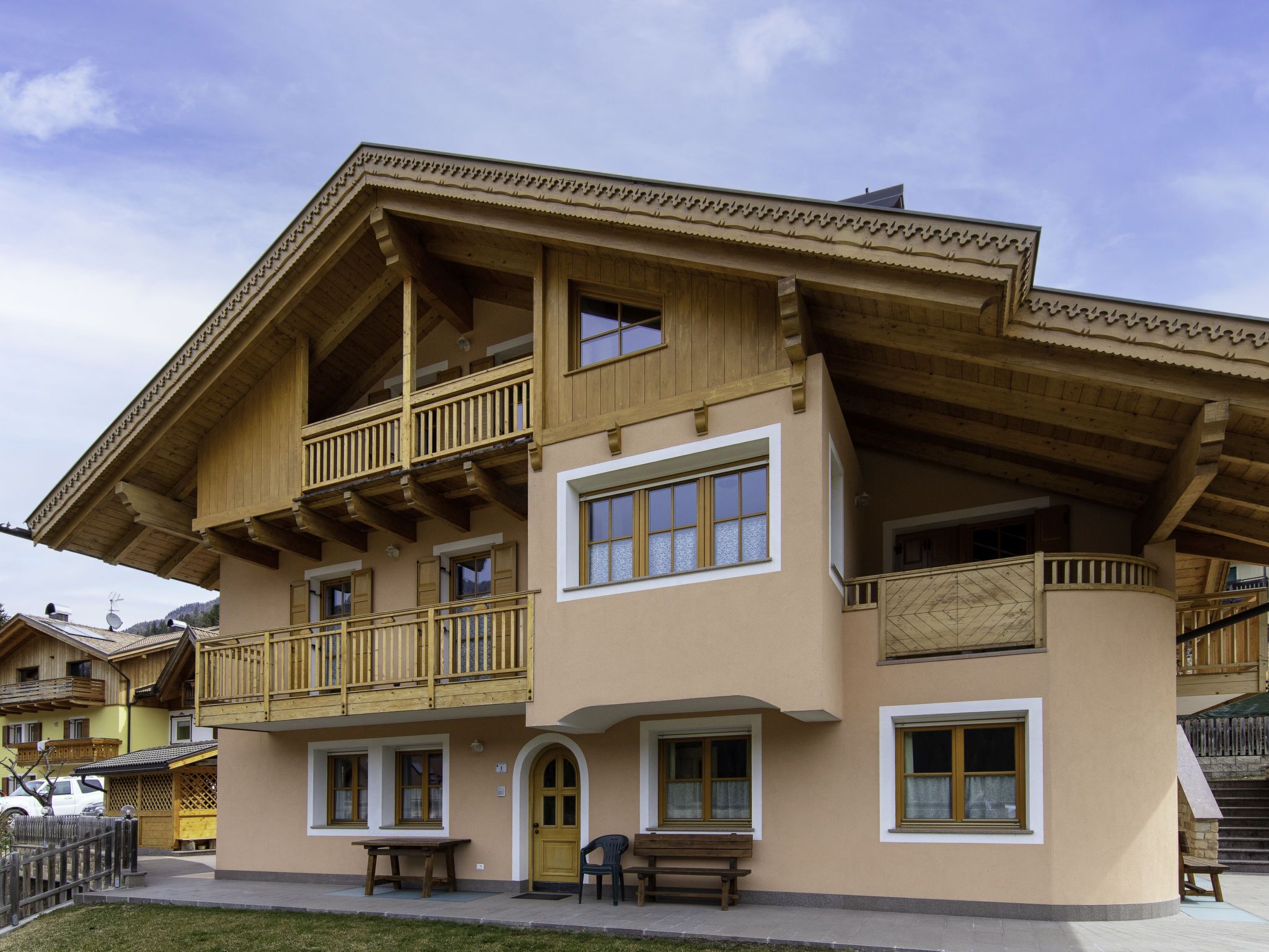 Un edificio de varios pisos con balcones de madera y grandes ventanales.
