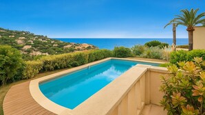 Piscina com vista para o mar e uma encosta.