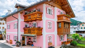 A multi-story building with balconies, wooden railings, and a sloped roof.