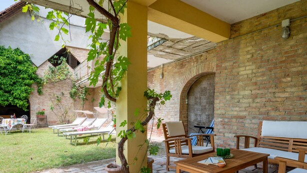 Une terrasse extérieure avec un sol en briques, des meubles en bois et un mur en briques.