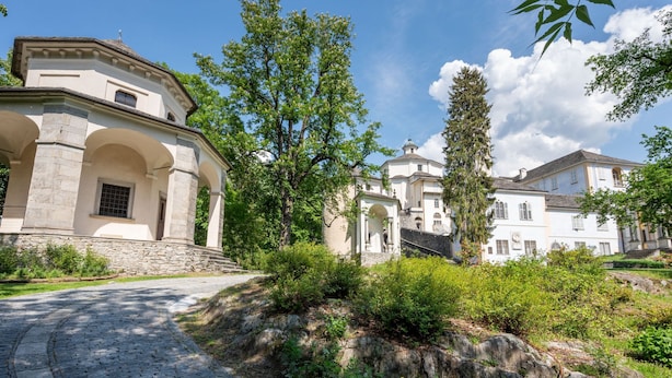 Un edificio histórico con arquitectura clásica, que presenta arcos en las entradas y fachada de piedra.