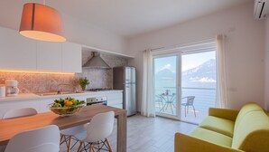Una cuina moderna amb zona de menjador, sofà i vista al mar.