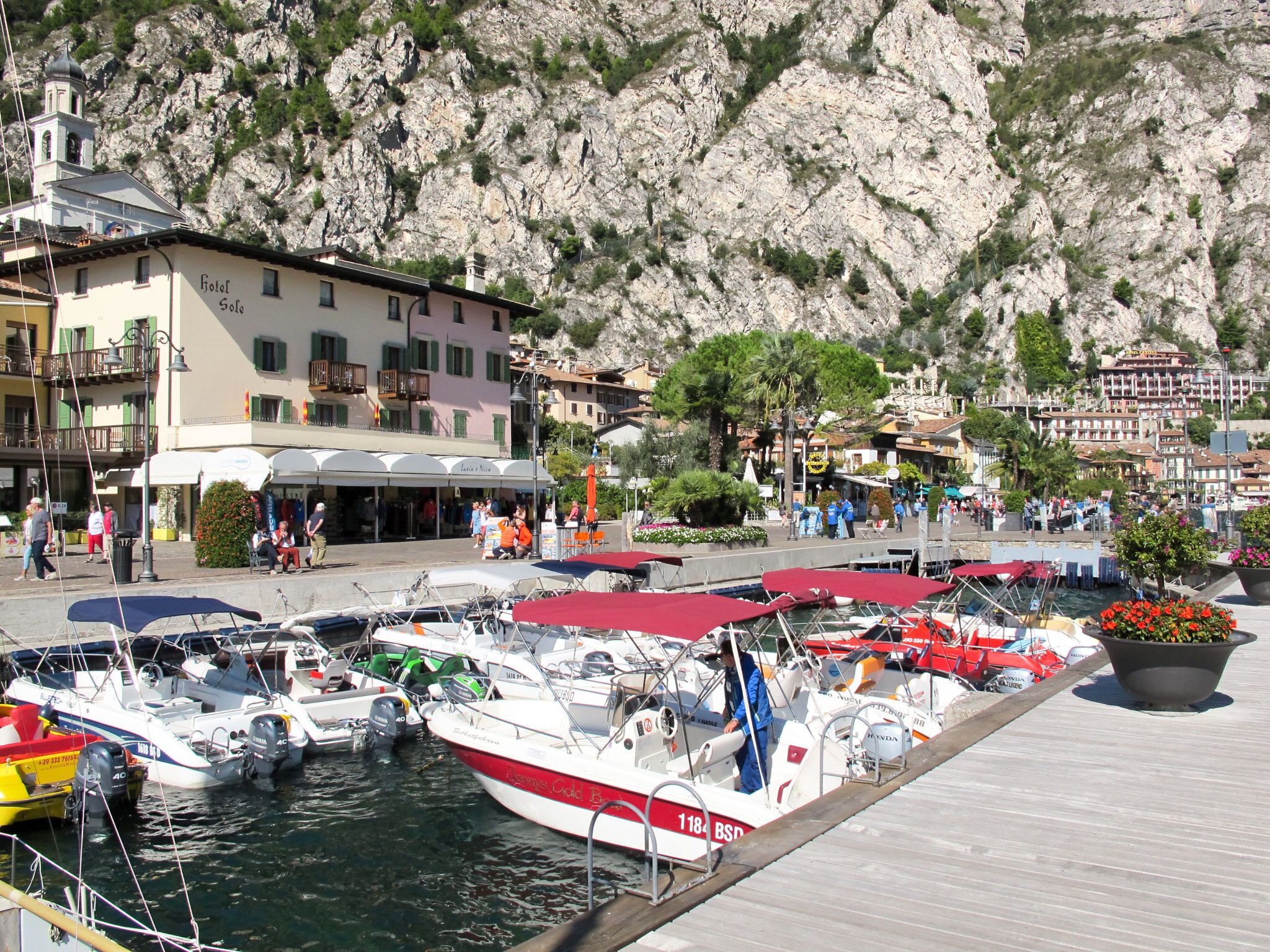 Ein Yachthafen mit vertäuten Booten, im Hintergrund ein Hotel namens "Hotel Solo" und ein felsiger Hügel.