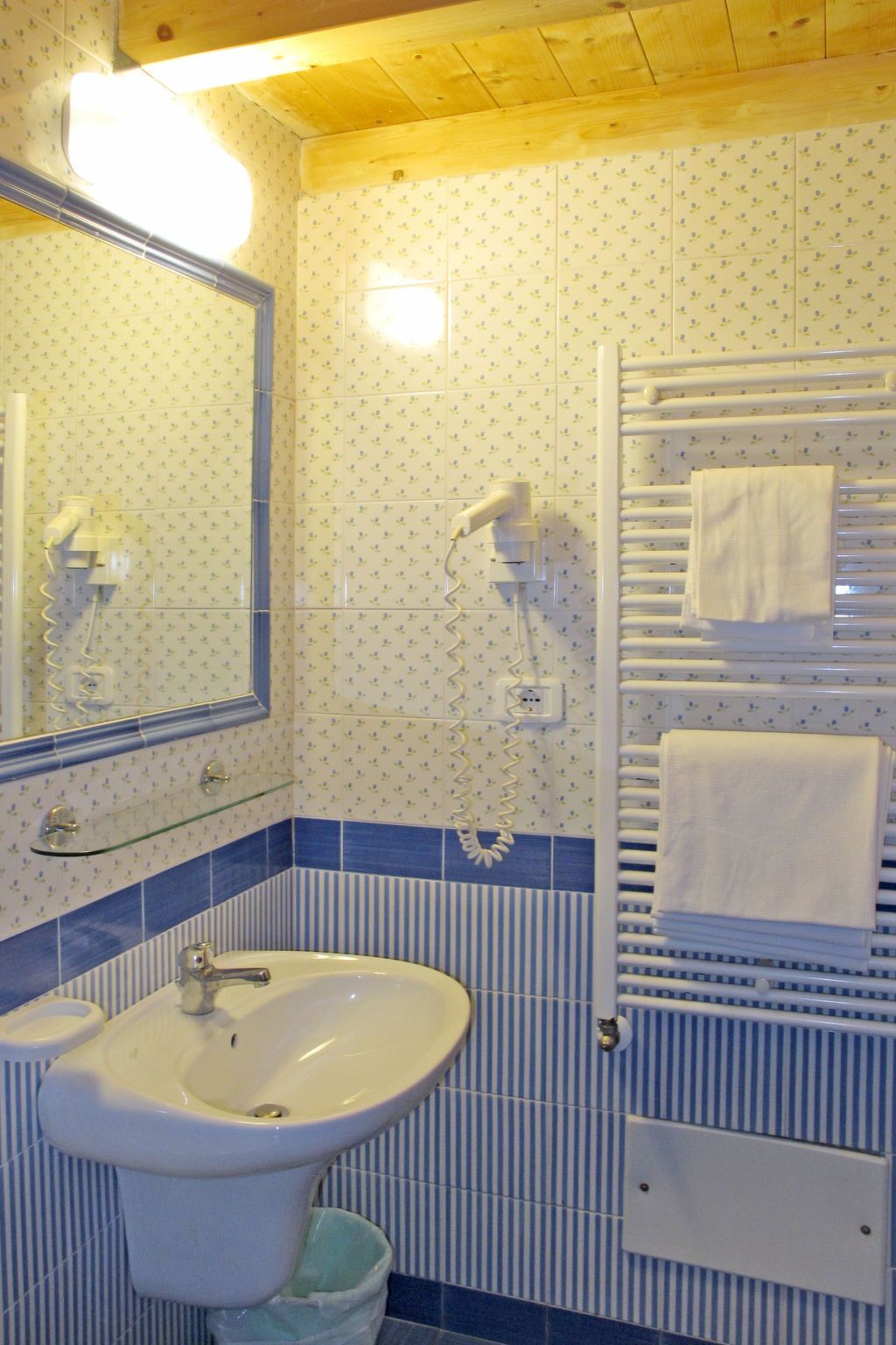 A bathroom with a sink, mirror, and towel rack.